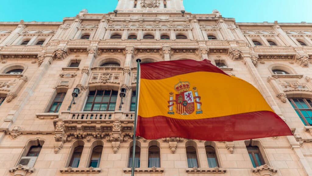 A Spanish flag outside an ornate government building in Madrid