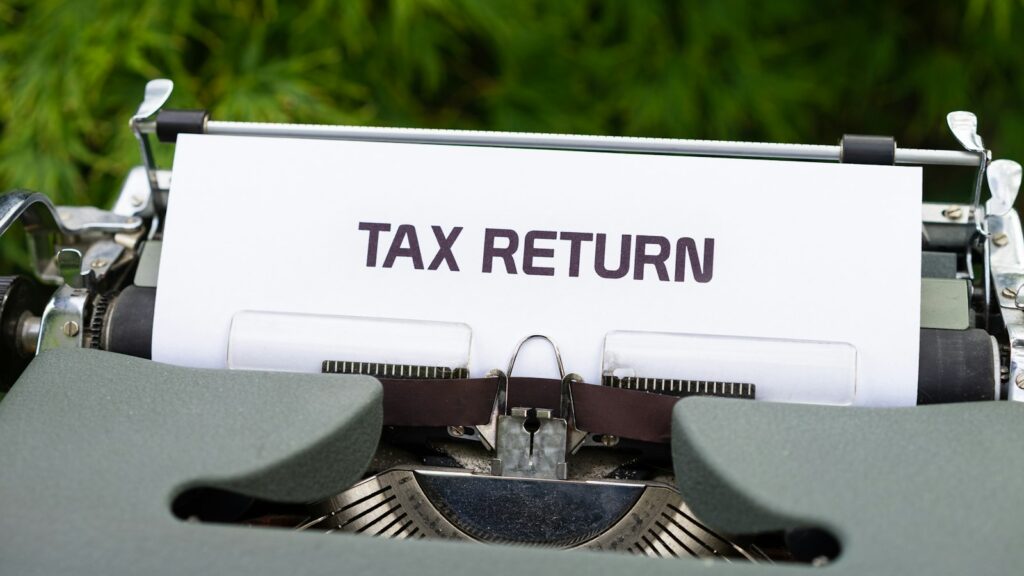 A typewriter with a sheet of paper reading Tax Return