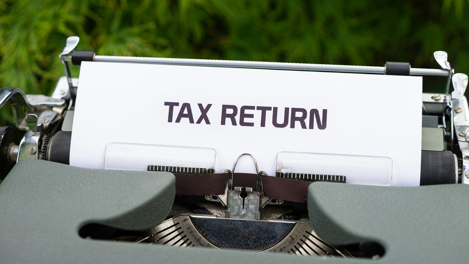 A typewriter with a sheet of paper reading Tax Return