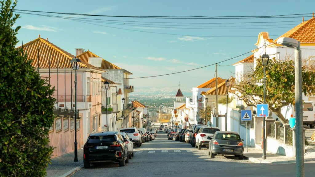 A town street with road signs and parked cars in Portugal