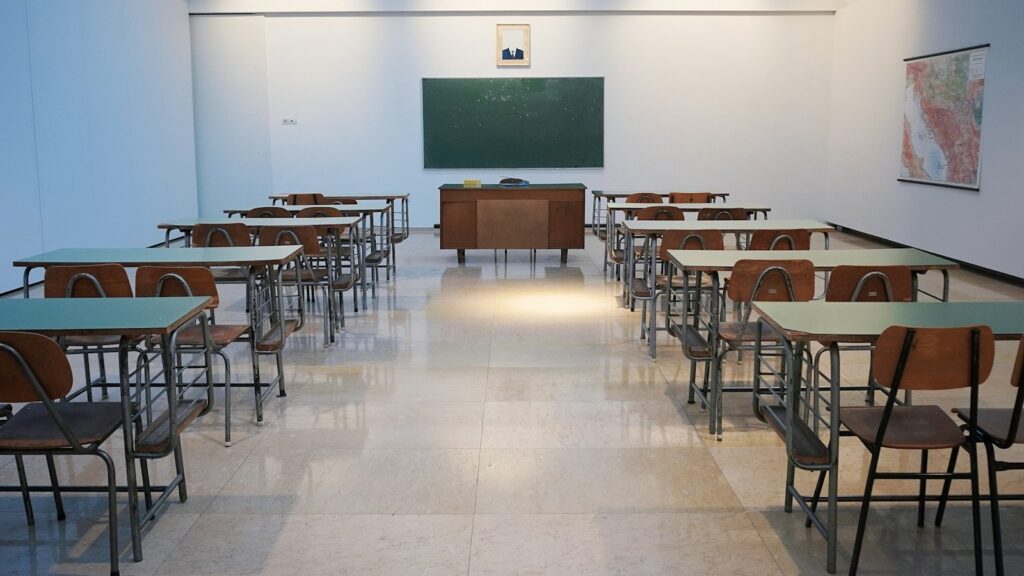An empty classroom with desks and a chalkboard