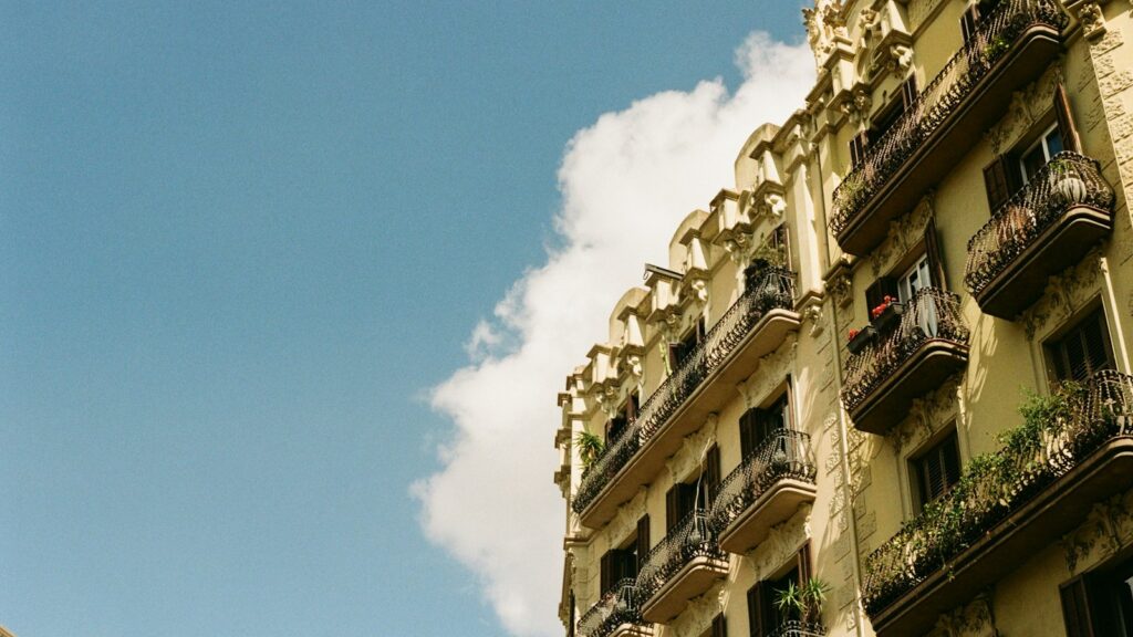 An ornate yellow apartment building with wrought-iron balconies in Barcelona, Spain