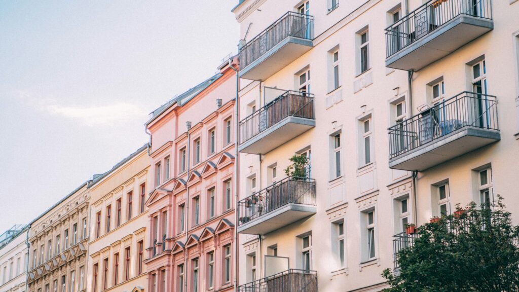 A row of pastel-coloured apartment buildings with balconies in Berlin, Germany