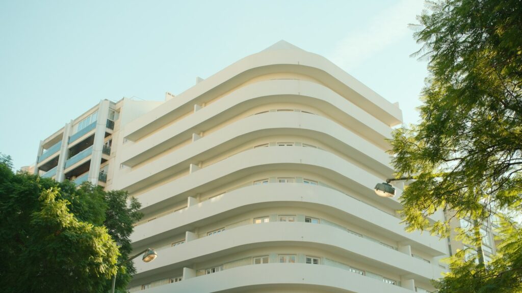 A white residential apartment building with curved balconies in Entrecampos, Lisbon