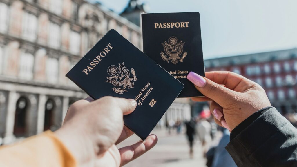 Two passports held up in a historic square in Madrid, Spain